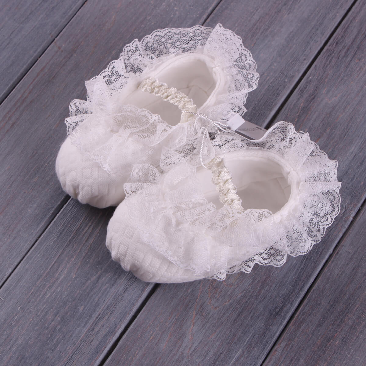 Christening Booties  on a wooden surface