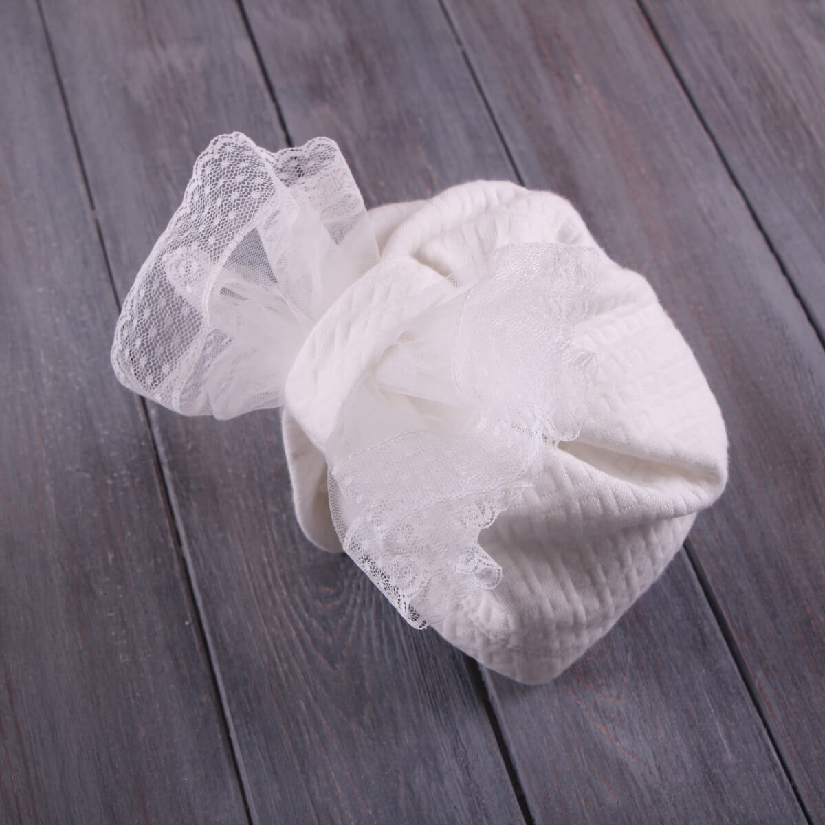 Lace Christening Bonnet on a wooden surface