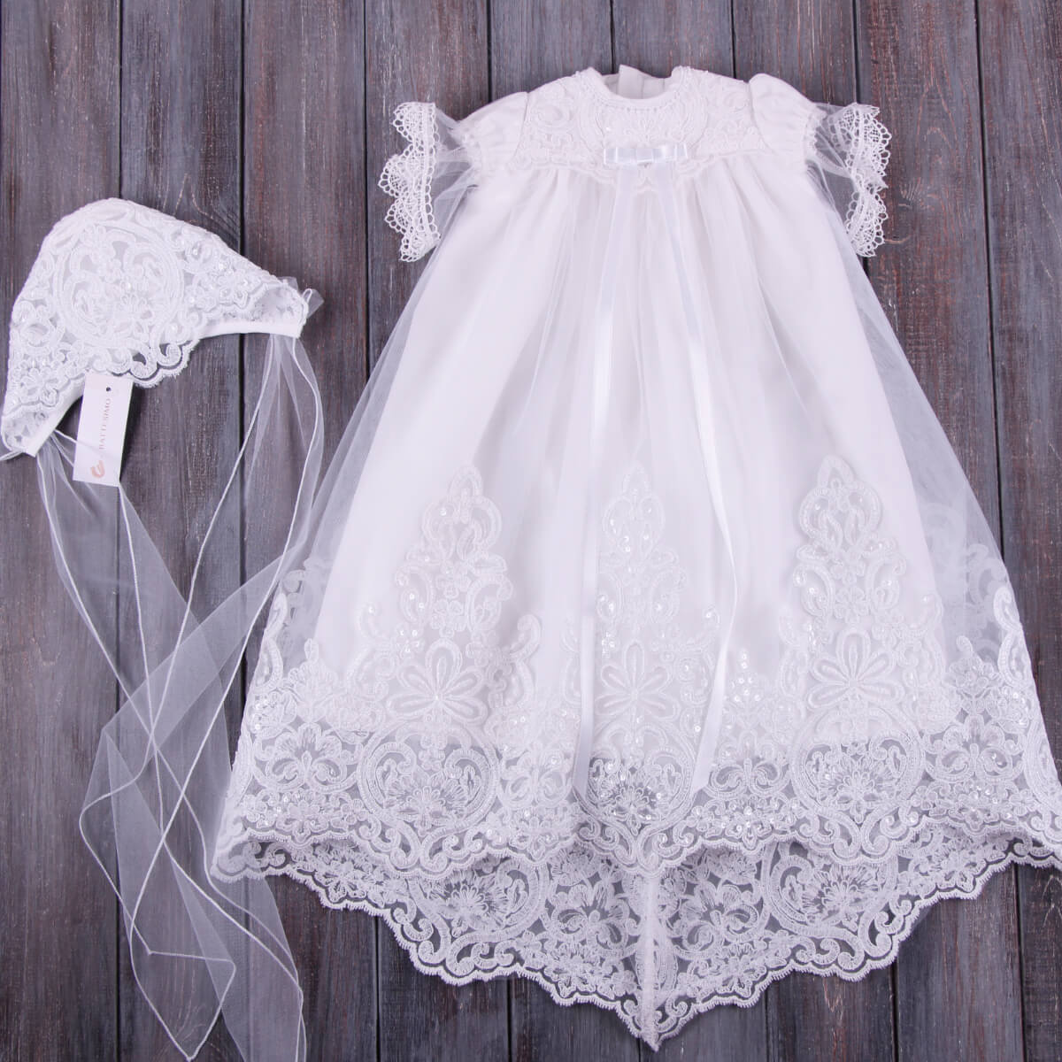 Christening Gown with Train for Girls  with matching hat on a wooden background