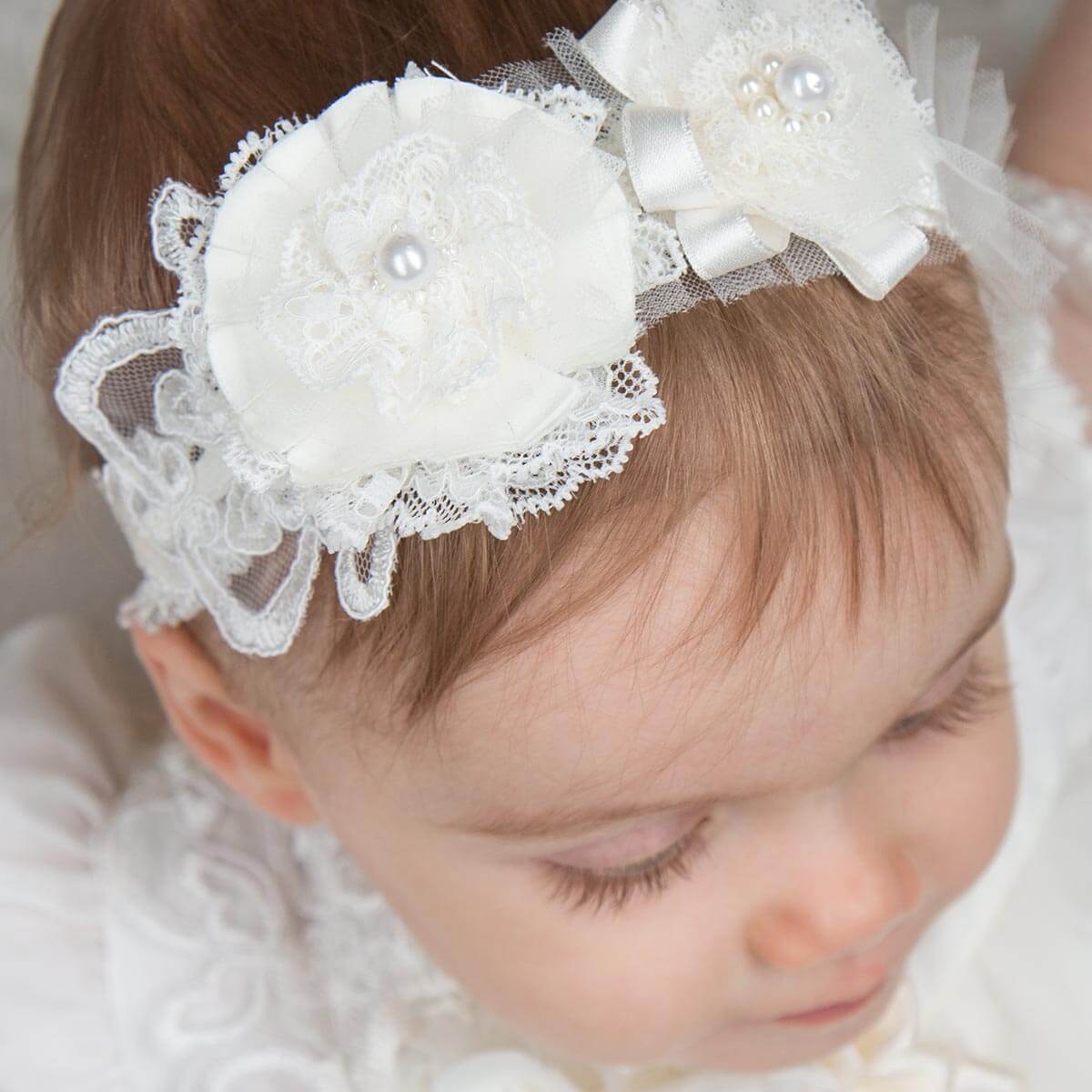 Child wearing a decorative baby headband with flowers and pearls