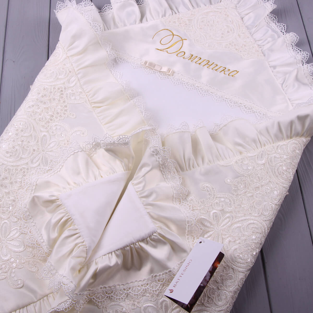 White lace christening blanket embroidery on a gray surface