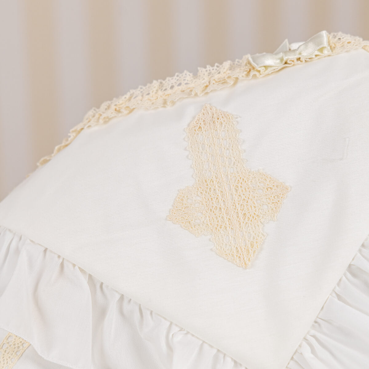 ivory baptism blanket with lace cross on a plain background