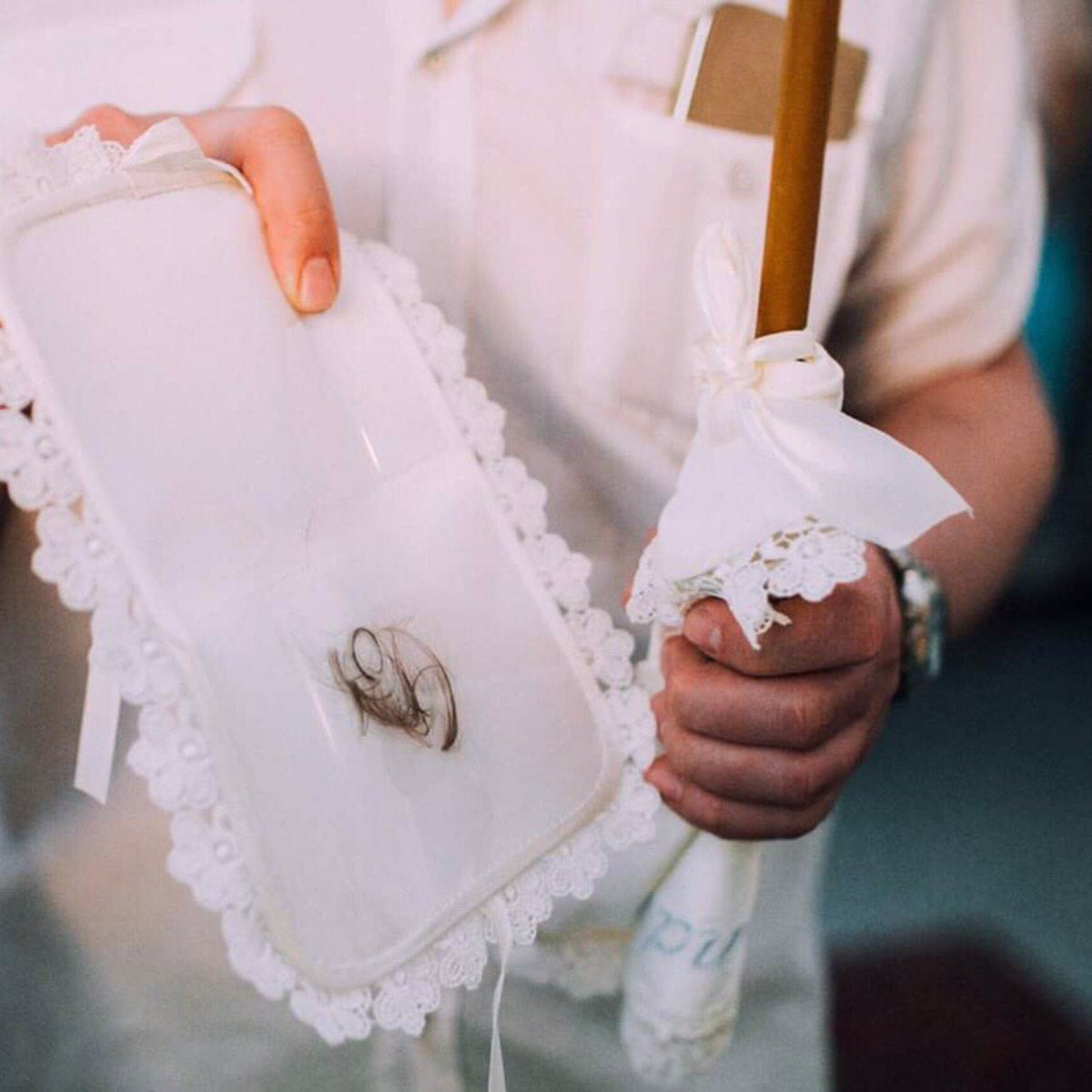 Close-up of hands holding a white lace parasol and a Baptism Keepsake Box with a design.