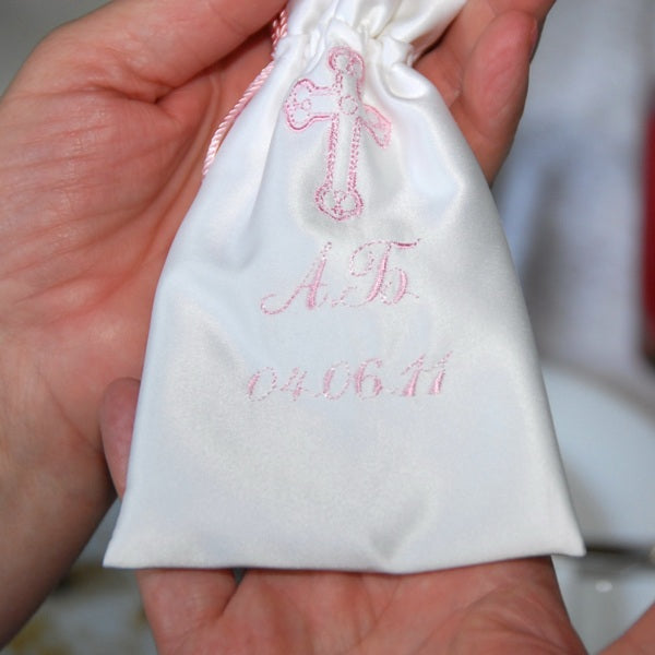 Baptism Keepsake Bonbonniere with pink embroidery held in a hand