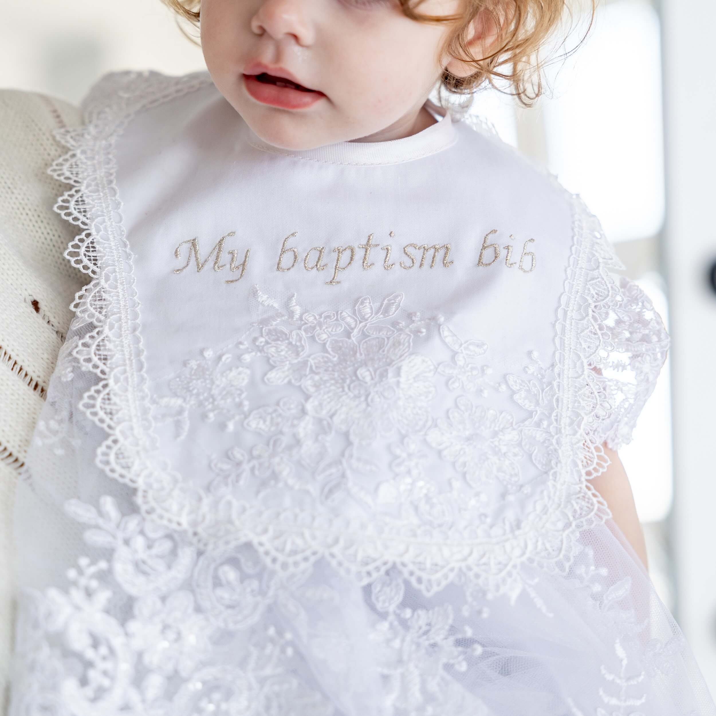 Baptism Bib with 'My baptism bib' text worn by a child