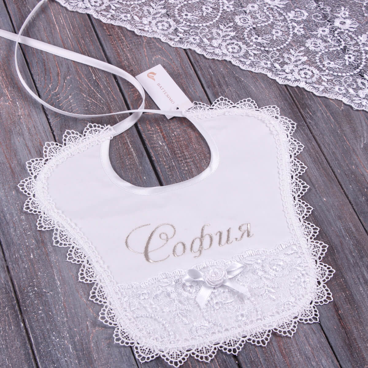 Baptism Bib with embroidered name on a wooden surface