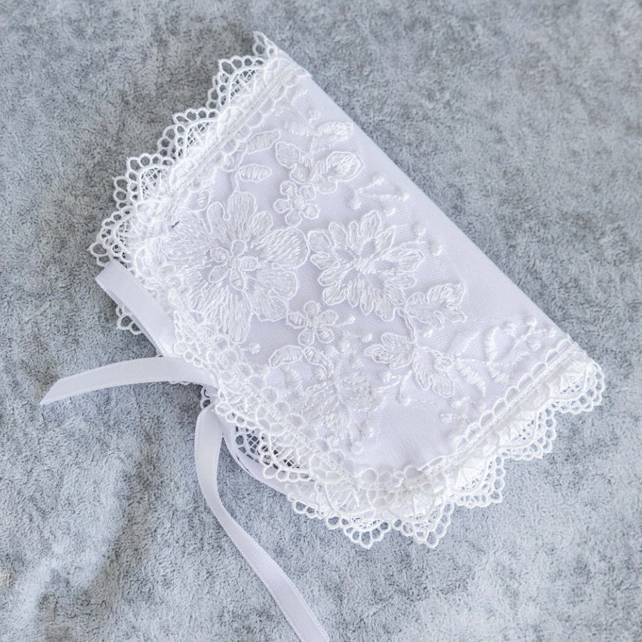 White lace handkerchief with a ribbon on a textured gray surface